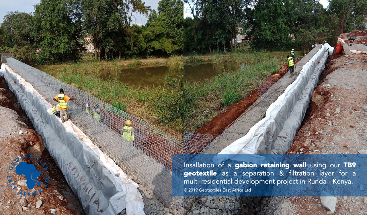 geotextile backing being installed behind gabion retaining wall